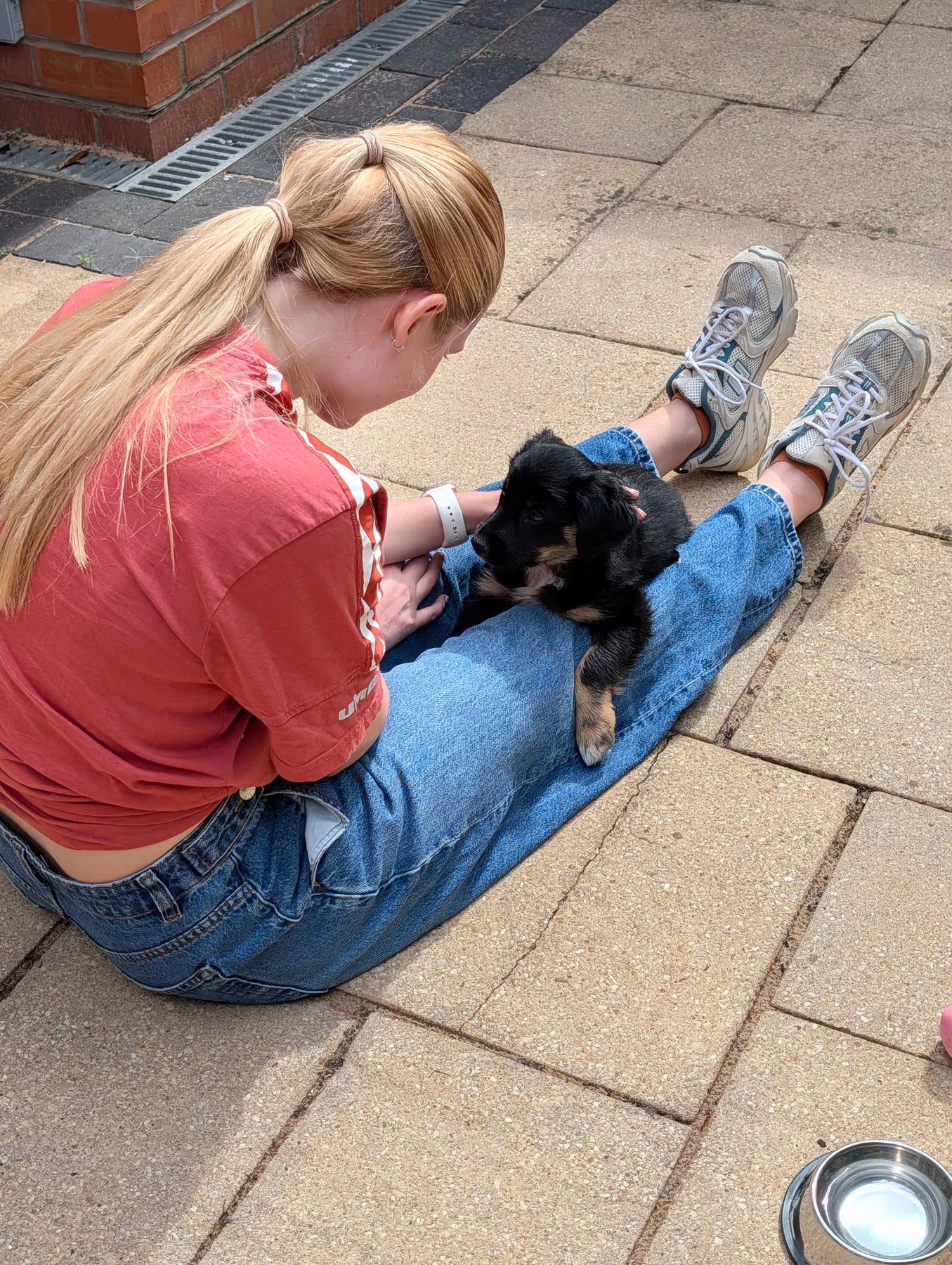 Annie lying across Alisha's leg on the patio
